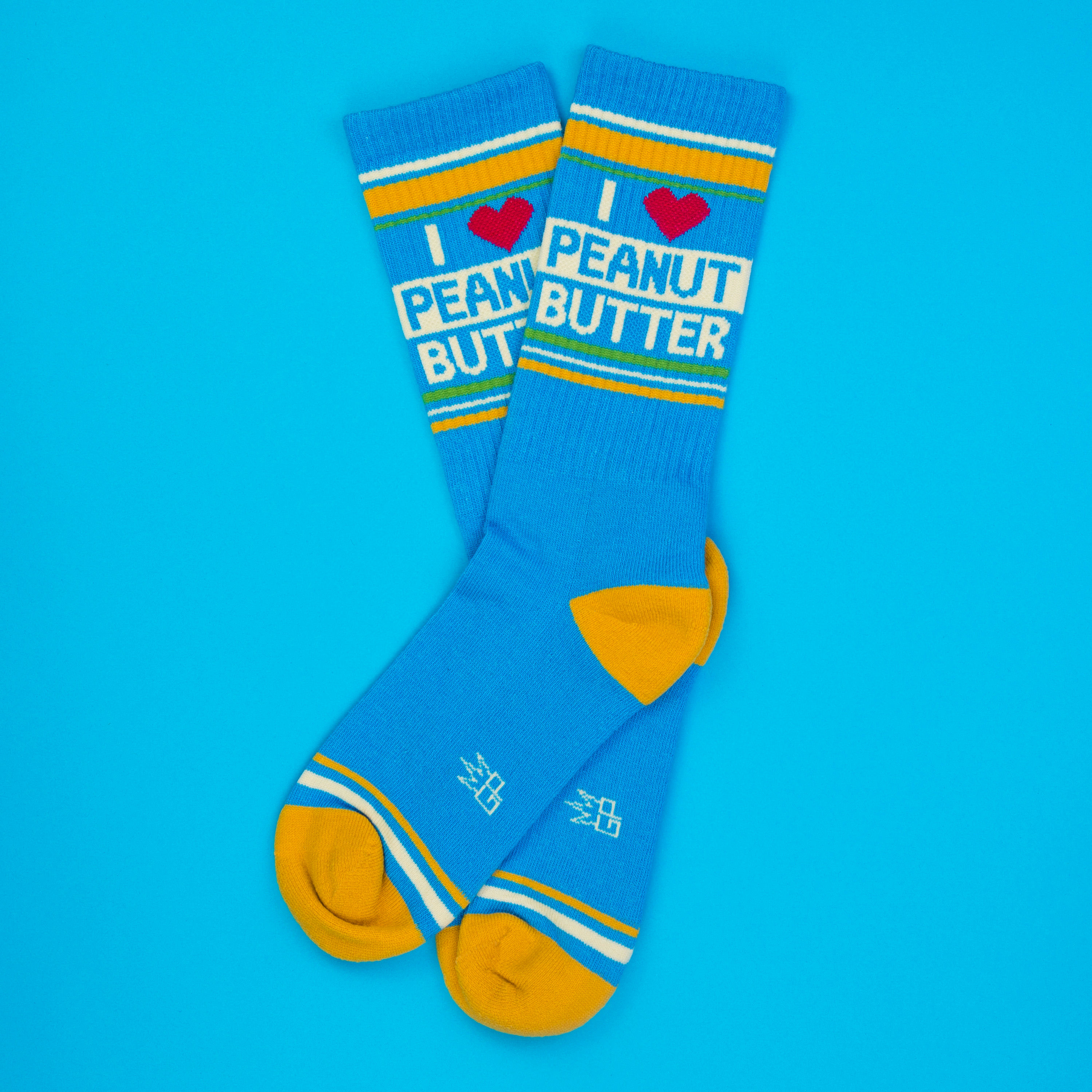Lifestyle shot of a single 'I Heart Peanut Butter' sock casually displayed on a blue background.