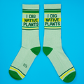 Flatlay product shot of a pair of 'I Dig Native Plants' socks on a bright blue background.