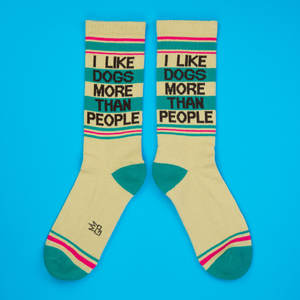 Flatlay of two 'I Like Dogs More Than People' socks on a blue background.