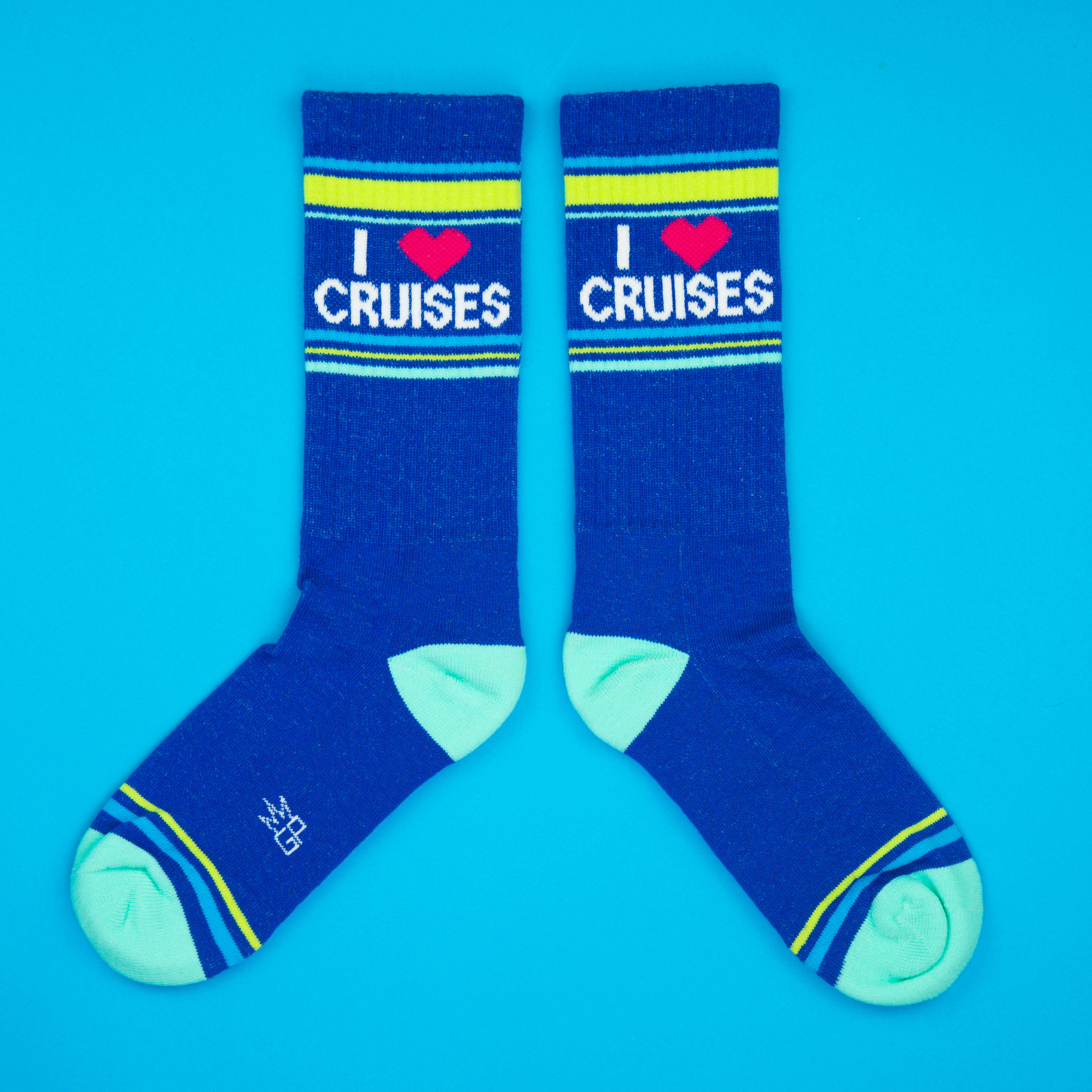 Flat lay product shot of a pair of 'I Heart Cruises' socks on a bright blue background.