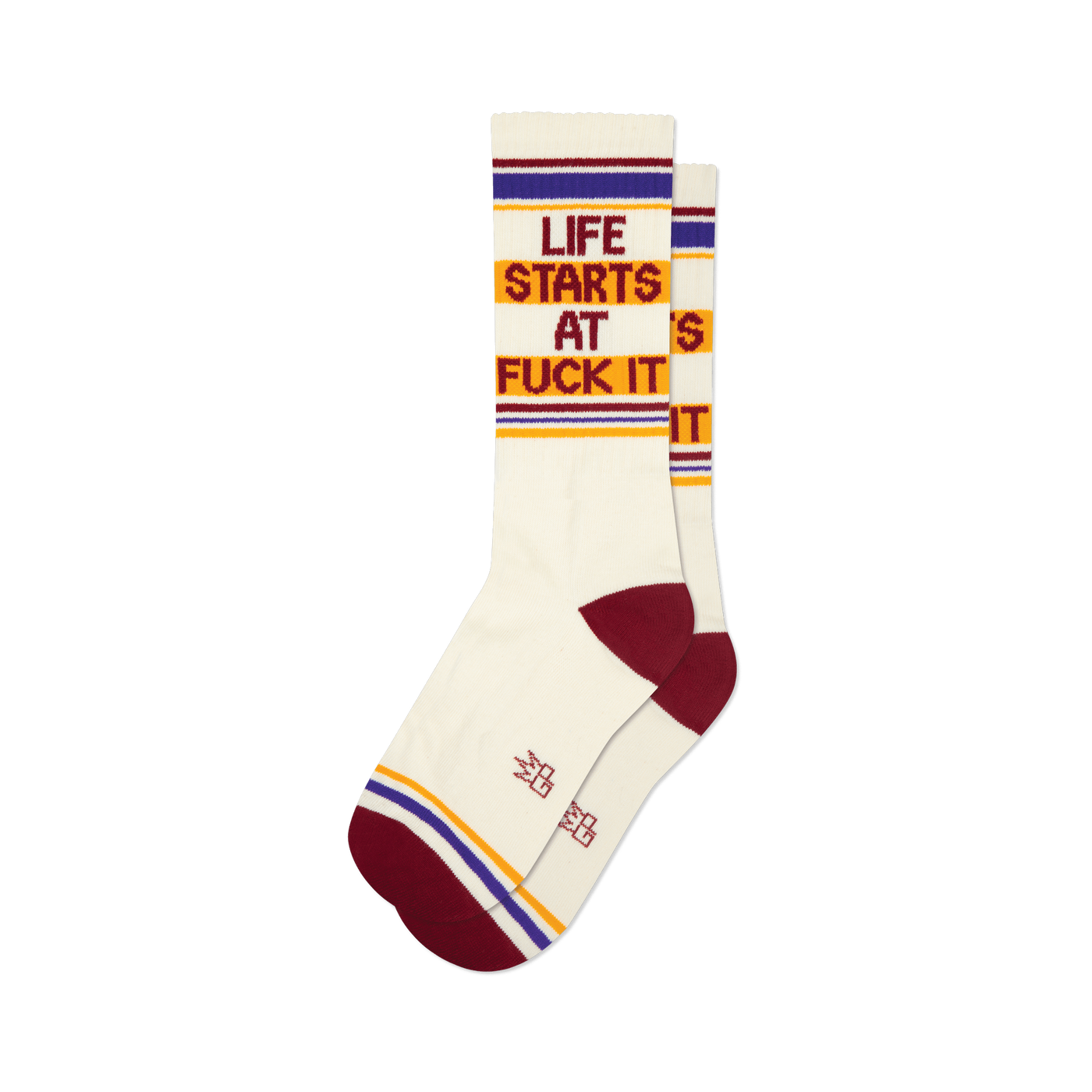 Pair of cream crew socks with maroon, gold, and purple stripes and the phrase 'Life Starts At Fuck It' in a retro font.