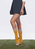 Lifestyle shot showing a woman wearing a pair of No. 2 Pencil socks with a navy skirt. [lf]