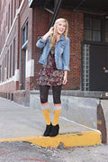 A woman wearing the No. 2 Pencil knee-high socks in an outdoor lifestyle shot. She is wearing a floral dress and denim jacket. [lf]