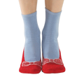 A lifestyle shot of a person wearing the red and light blue non-skid slipper socks.