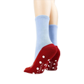 Flatlay showcasing both socks, highlighting the red slipper design and non-skid dots on the bottom.