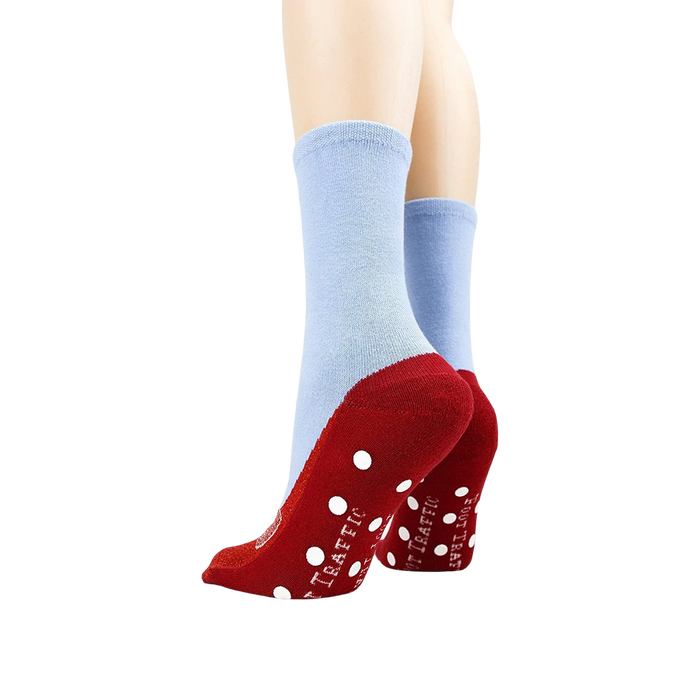 A pair of blue socks with red soles and a red bow on the toes. The soles have white polka dots and the words 