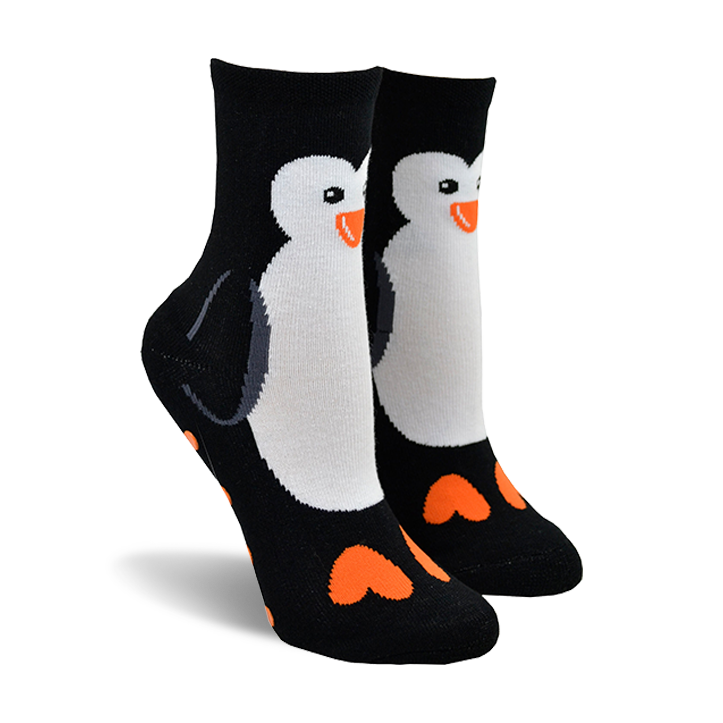 Pair of black crew socks with a white penguin design and orange heart-shaped feet. 