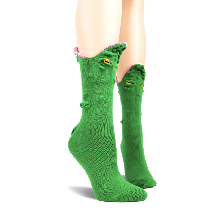 Green crew socks with a 3D alligator face design.  The alligator's mouth is playfully open, showing pink textured inside, yellow eyes are embroidered on.