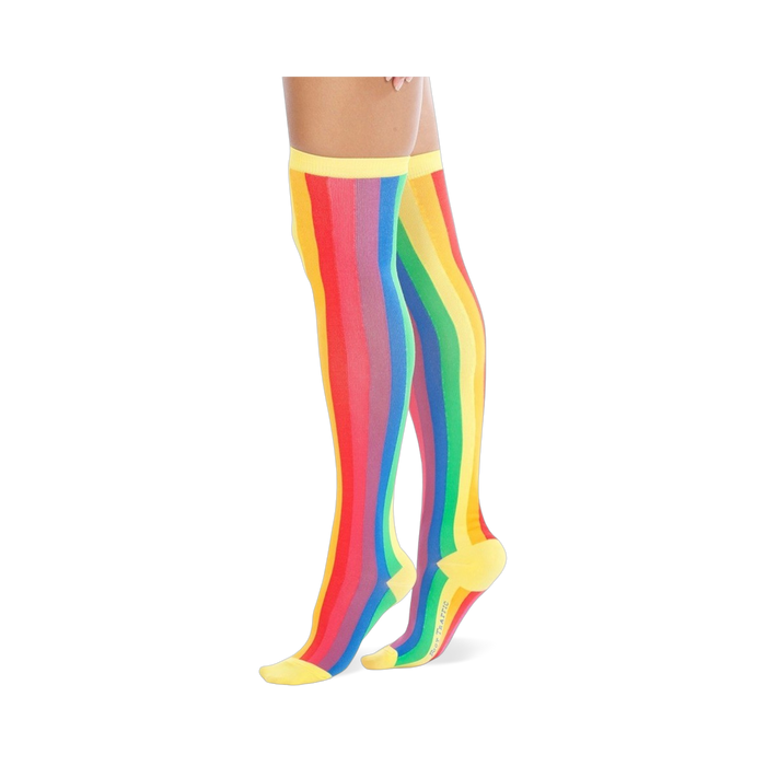 A pair of women's over-the-knee socks with vertical rainbow stripes. The socks are predominantly red, orange, yellow, green, blue, and purple, with yellow cuffs. }}