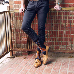 Close-up of black knee-high socks showing the violin and musical notes design.