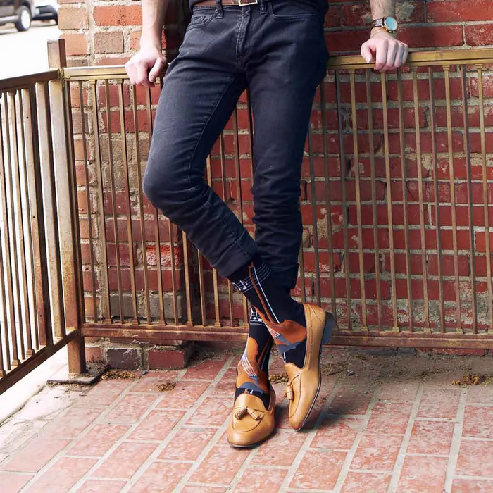 Close-up of black knee-high socks showing the violin and musical notes design.