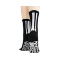 Rear view of model's legs wearing black skeleton socks with grey non-skid bottoms against a black background.