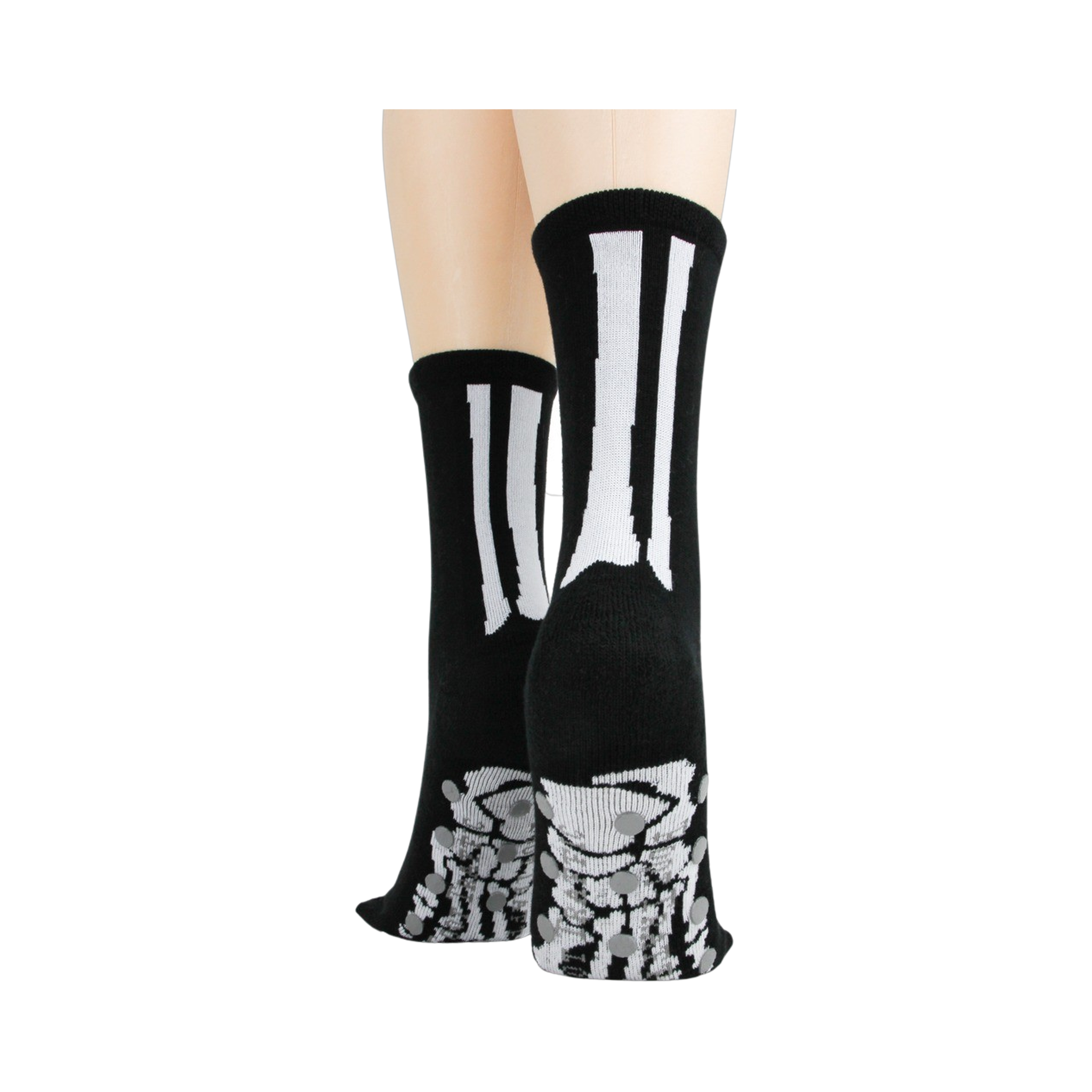 Rear view of model's legs wearing black skeleton socks with grey non-skid bottoms against a black background.