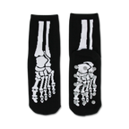 Pair of black non-skid slipper socks with a white skeleton bone design. Grippy dots on the bottom.