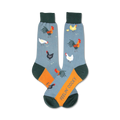 A pair of crew socks in blue, orange, and green. The socks are decorated with a pattern of roosters, hens, and chicks.