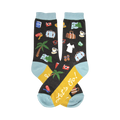 Crew socks with a dark background featuring colorful travel-themed illustrations like palm trees, suitcases, and cameras. Teal cuffs and yellow heel with 'Let's Go!' text.