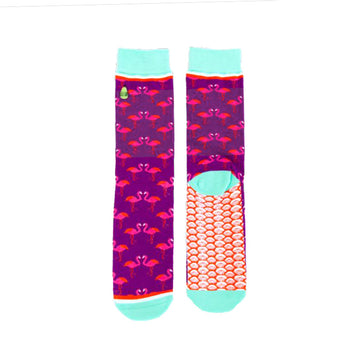 Pair of crew socks. Purple background with pink flamingo design. Teal cuffs and orange scale pattern on the soles.