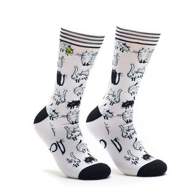 A pair of white crew socks covered in a repeating pattern of black and white cartoon cats. The socks have black heels and toes.