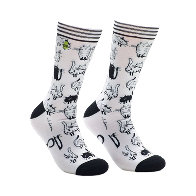 A pair of white crew socks covered in a repeating pattern of black and white cartoon cats. The socks have black heels and toes.