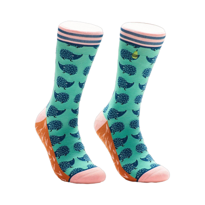 Pair of teal crew socks with a navy hedgehog pattern, pink and orange accents, and a small yellow pear graphic.