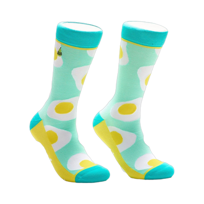 Crew socks with a mint green background and a repeated pattern of sunny-side up eggs in yellow and white. Turquoise accents at the top and bottom.
