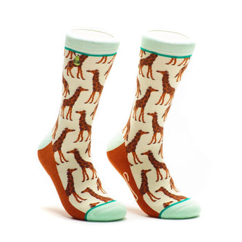 Cream crew socks with a repeating pattern of brown giraffes.  Mint green and orange accents are on the cuff and heel.