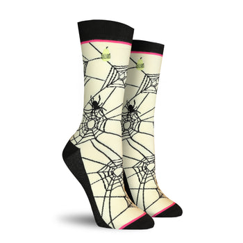 Pair of cream crew socks featuring a black spiderweb design, black spiders, and small lime green cupcake accents.
