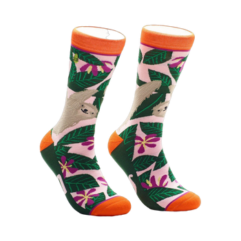 A pair of crew socks with a pink, green, and orange design.  The socks feature sloths hanging from tropical leaves and flowers.