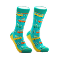 A pair of crew socks in teal, yellow, orange, and white. The design features repeating illustrations of vintage camper vans and pine trees.