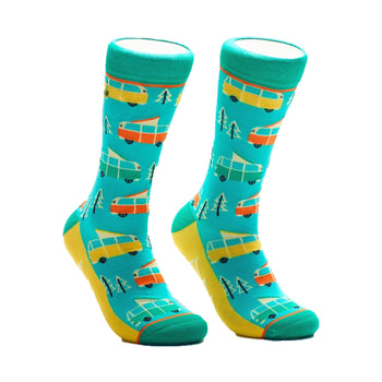 A pair of crew socks in teal, yellow, orange, and white. The design features repeating illustrations of vintage camper vans and pine trees.