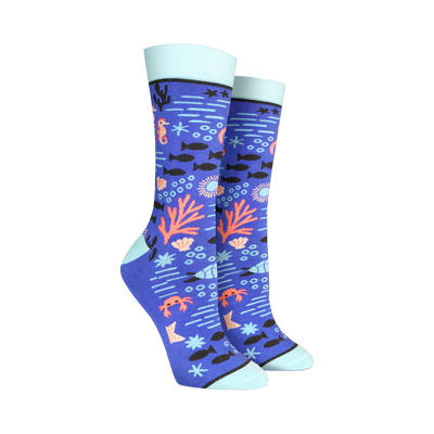 A pair of women's crew socks in blue, adorned with a whimsical undersea design featuring seahorses, coral, fish, and crabs.