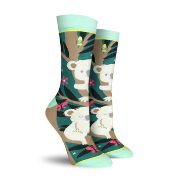 Crew socks with a teal, brown, and pink design. Koalas are featured on a eucalyptus tree background with pink flowers and butterflies.