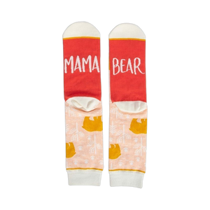Pair of women's crew socks. Peach background with gold bear design. Red heel and toe with 'Mama Bear' text.