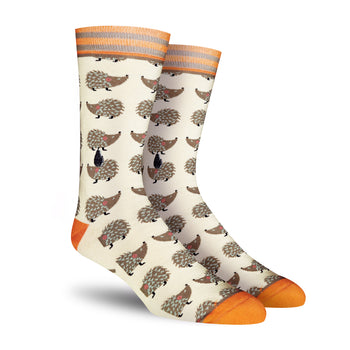 Cream crew socks featuring a repeating pattern of brown hedgehogs. Orange and gray stripes accent the cuffs and toes.