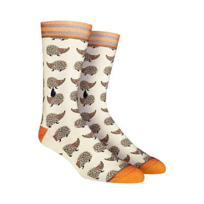 Cream crew socks featuring a repeating pattern of brown hedgehogs. Orange and gray stripes accent the cuffs and toes.