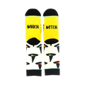A pair of crew socks with a yellow cuff and cream body. The socks feature a pattern of black witch hats with colorful accents.  The cuff reads 'Which Witch'.