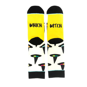 A pair of crew socks with a yellow cuff and cream body. The socks feature a pattern of black witch hats with colorful accents.  The cuff reads 'Which Witch'.