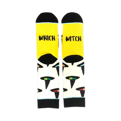 A pair of crew socks with a yellow cuff and cream body. The socks feature a pattern of black witch hats with colorful accents.  The cuff reads 'Which Witch'.
