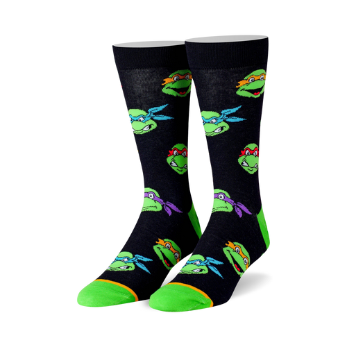 Crew socks in black with colorful Teenage Mutant Ninja Turtle head graphics. Lime green accents on the toes and heels.