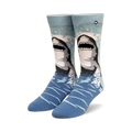 Pair of crew socks, blue and gray, with a great white shark design emerging from the water. 