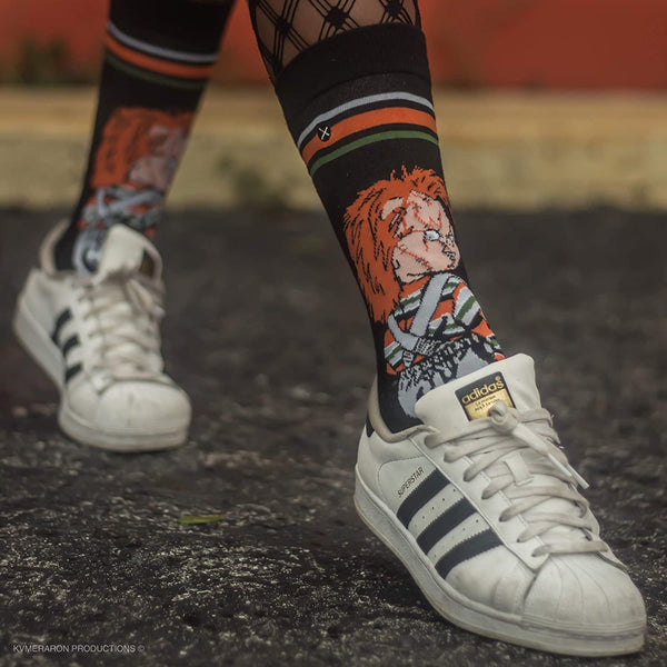 Lifestyle shot: Person wearing Chucky socks with Adidas Superstar sneakers. [lf]