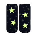 Close-up showing the Starry Night Glow socks glowing in the dark; the white stars illuminate a bright, pale yellow-green.