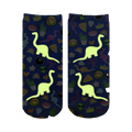 Close-up showing the Dino Madness Glow socks glowing in the dark; the dinosaurs and other elements are brightly illuminated against the blue background.