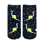 Close-up showing the Dino Madness Glow socks glowing in the dark; the dinosaurs and other elements are brightly illuminated against the blue background.