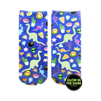 Pair of blue ankle socks with a fun print featuring glow-in-the-dark dinosaurs, rainbows, smiley faces, and other quirky elements.