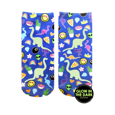 Pair of blue ankle socks with a fun print featuring glow-in-the-dark dinosaurs, rainbows, smiley faces, and other quirky elements.
