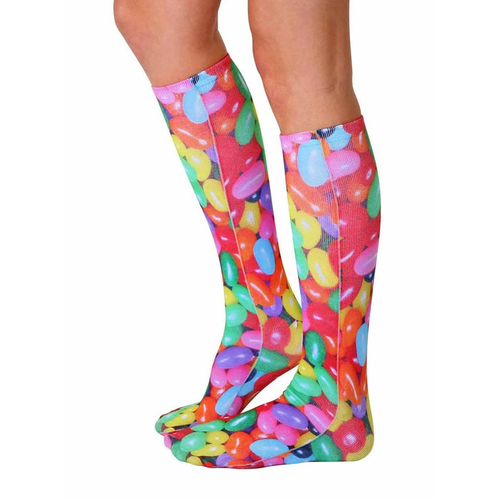 A pair of legs is shown wearing knee-high socks with a colorful pattern of jelly beans.