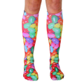 Pair of knee-high socks featuring a colorful jellybean print.  Red, green, yellow, pink, and purple jellybeans are scattered across a white background. [lf]