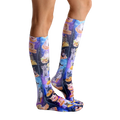 Lifestyle shot showing the socks on a person's legs, highlighting their length and the vibrant print. [lf]