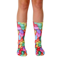 A pair of crew socks with a colorful jelly bean print.  The socks feature red, yellow, green, purple, and orange jelly beans on a white background. [lf]